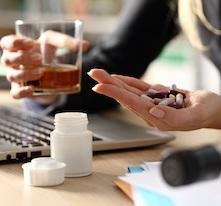 Femme qui prend des médicaments au travail