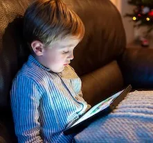 enfant devant un écran sur un canapé